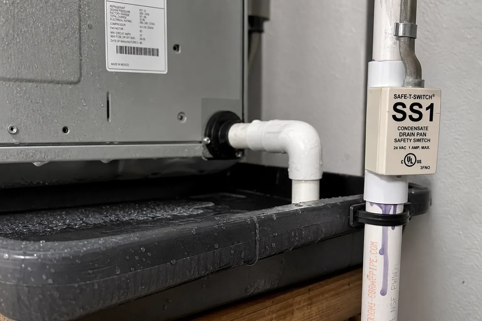 Indoor AC drain area showing moisture buildup after a storm in Pensacola