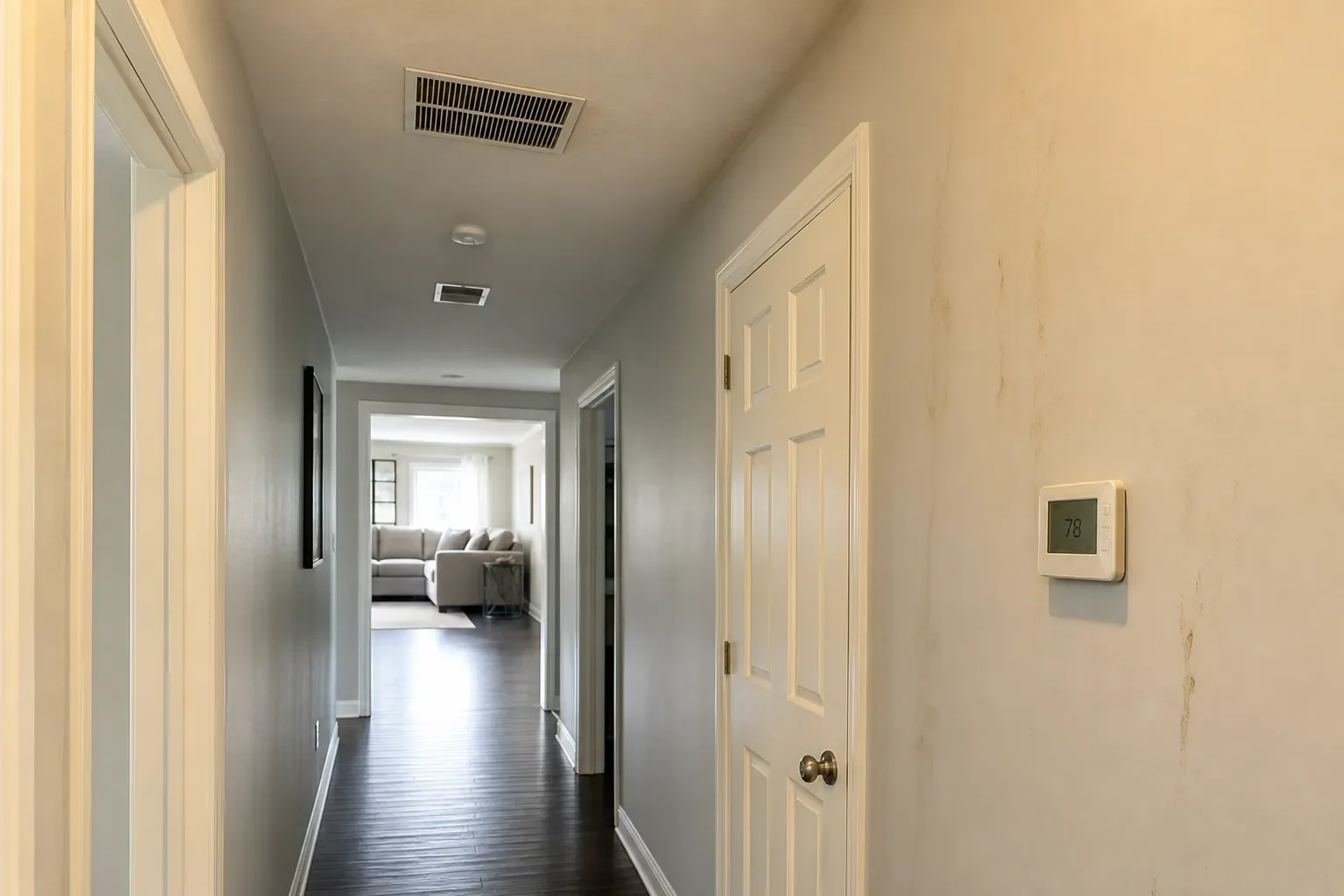 Interior view of a Milton home showing vents and thermostat related to central air replacement warning signs